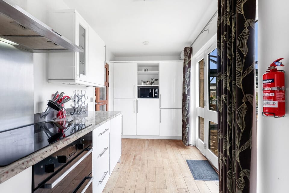 Galley-style kitchen with integrated appliances and timber flooring
