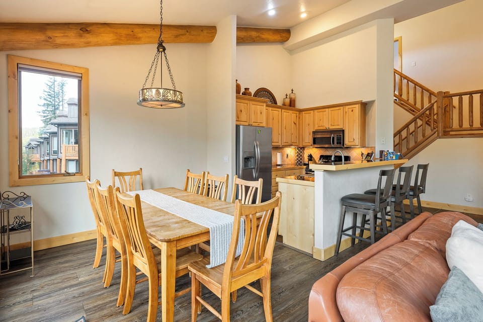 Dining area connected to kitchen for easy meal service   - Wood finishes and warm tones create cozy mountain style   - Perfect for group dinners or family friendly gatherings