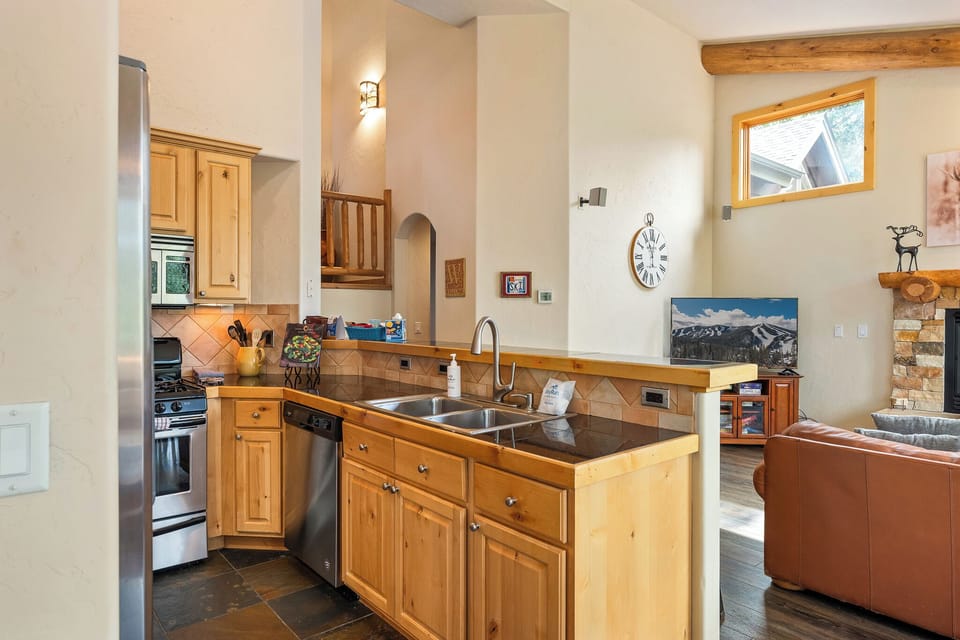 Kitchen with stainless steel appliances and wood cabinetry   - Spacious counters and double sink for easy meal preparation   - Perfectly equipped for cooking during a mountain getaway