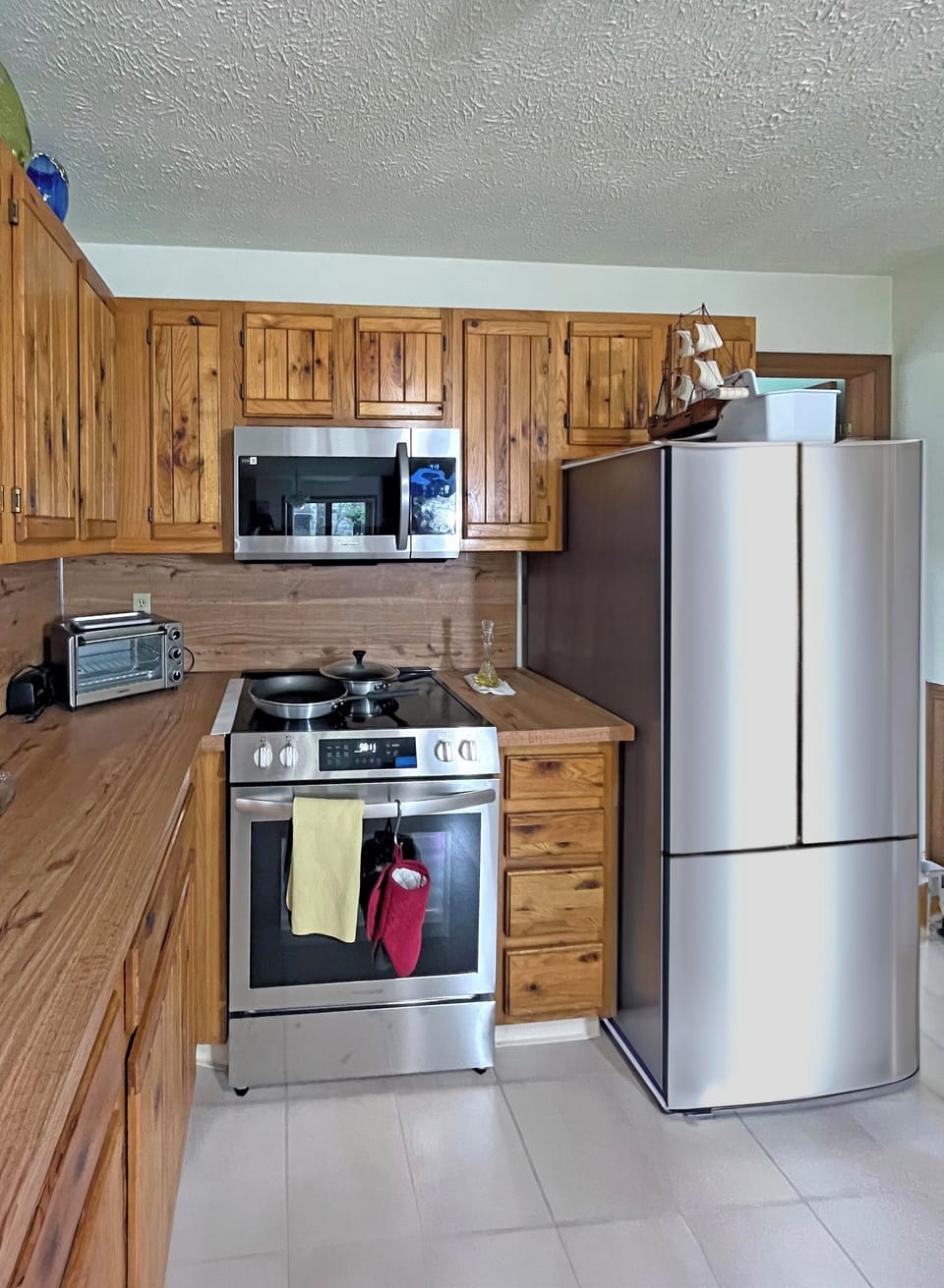 Fully equipped kitchen with modern appliances and rustic wood cabinetry.