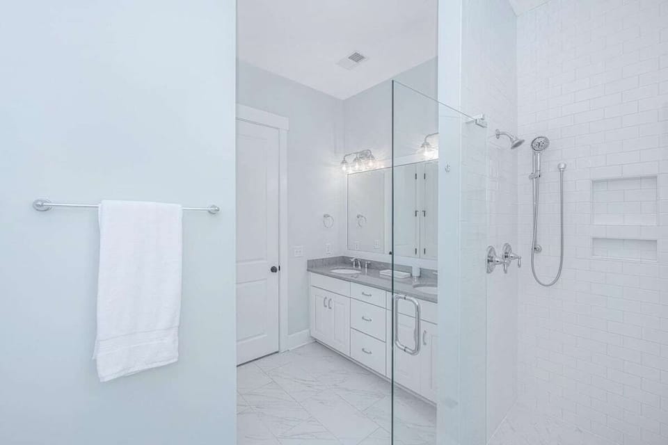 Modern bathroom with a spacious double vanity and a walk-in shower, perfect for shared use.