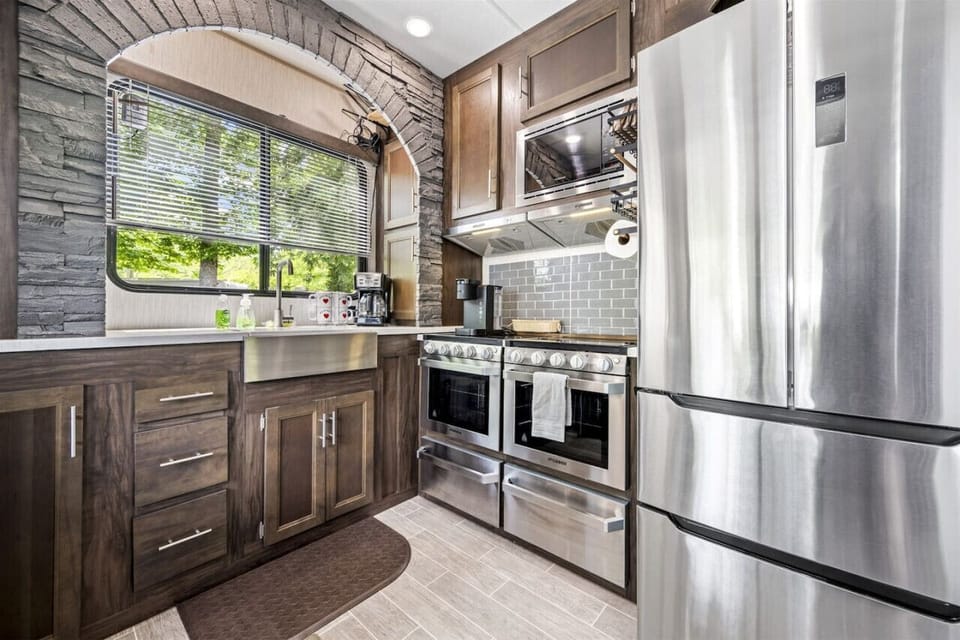 Full kitchen featuring stainless steel microwave, 2 stoves, and full-size fridge
