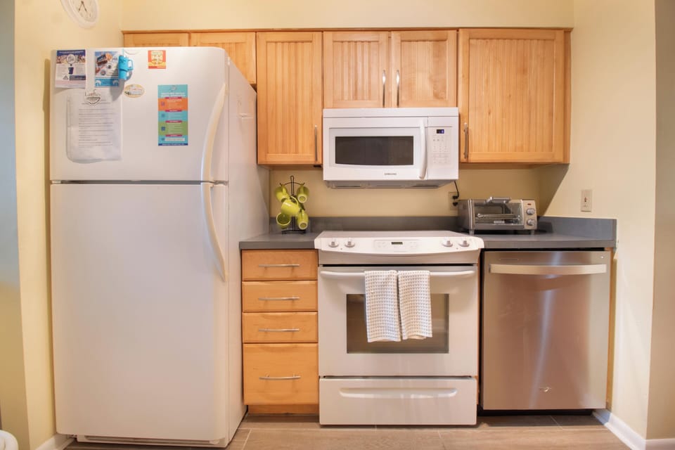 Your fully equipped kitchen features modern appliances and warm wood cabinets, perfect for preparing meals during your stay.