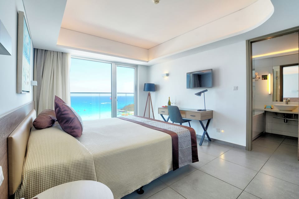Deluxe Suite, Sea View | Minibar, in-room safe, desk, soundproofing