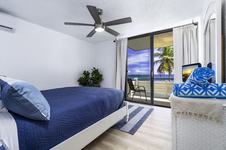 The primary bedroom with a queen bed and balcony access!