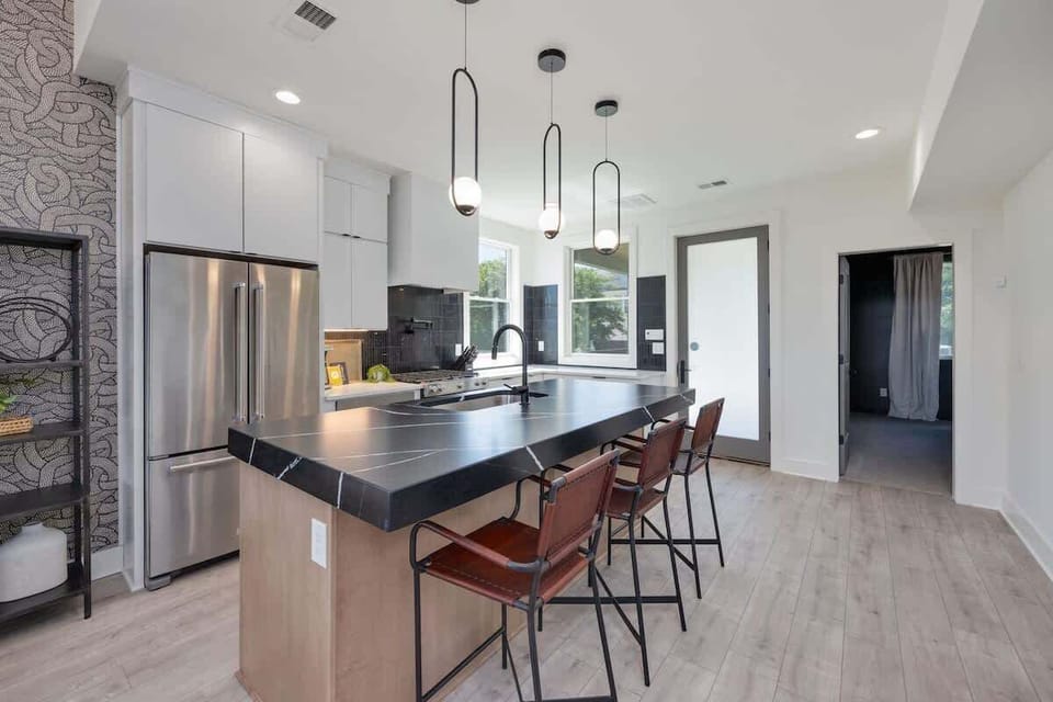 1st Floor: The fully equipped kitchen is stocked with all culinary essentials and boasts brand-new stainless-steel appliances with an oversized kitchen island offering bar seating.