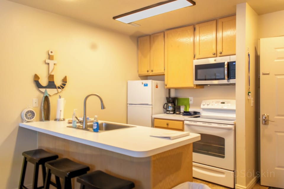 Kitchen - stove, oven, microwave, refrigerator,  bar with sink and dishwasher.