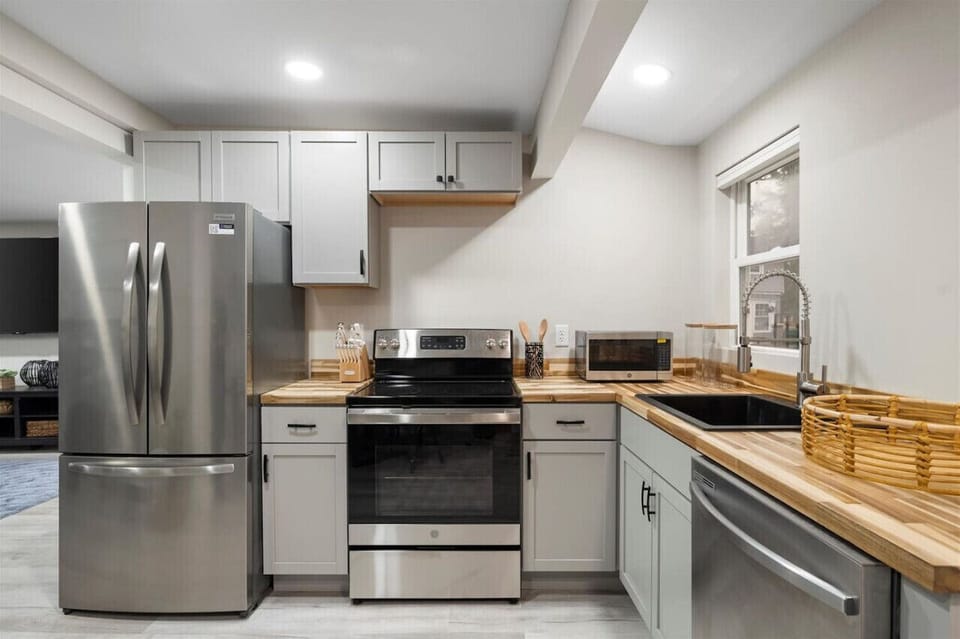 A fully equipped kitchen featuring stainless steel appliances, including a stove, refrigerator, microwave, and dishwasher, ready for culinary adventures.