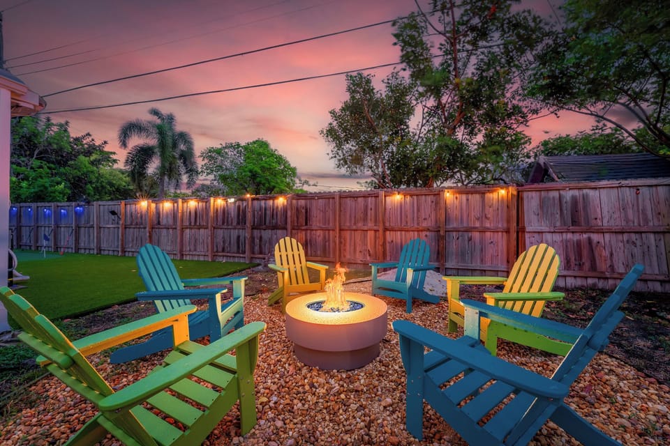 Colorful chairs around the bonfire, string lights adding a festive touch, all beneath a starry sky for a magical experience