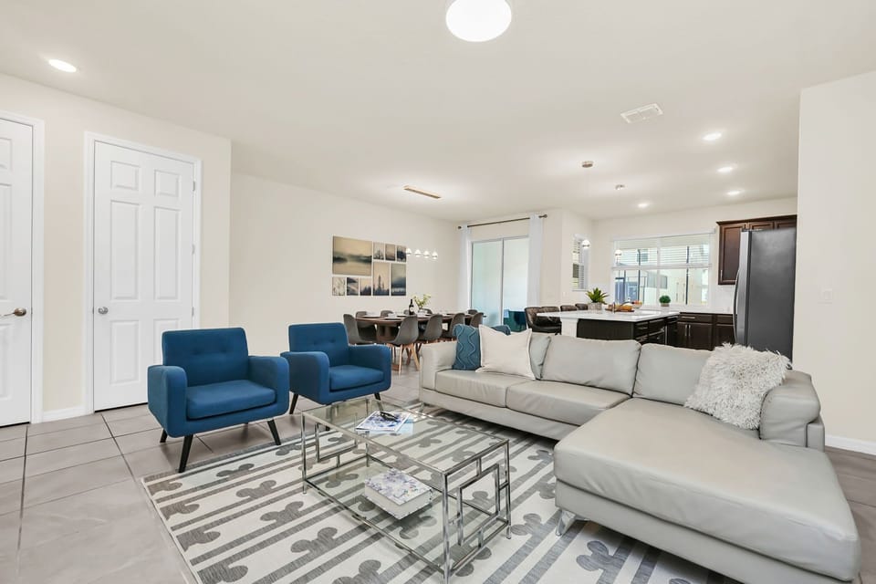 Open-concept living area with modern seating and natural light from large windows.