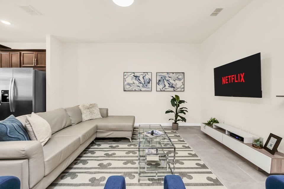 Modern living room with a large sectional sofa and wall-mounted television for entertainment.