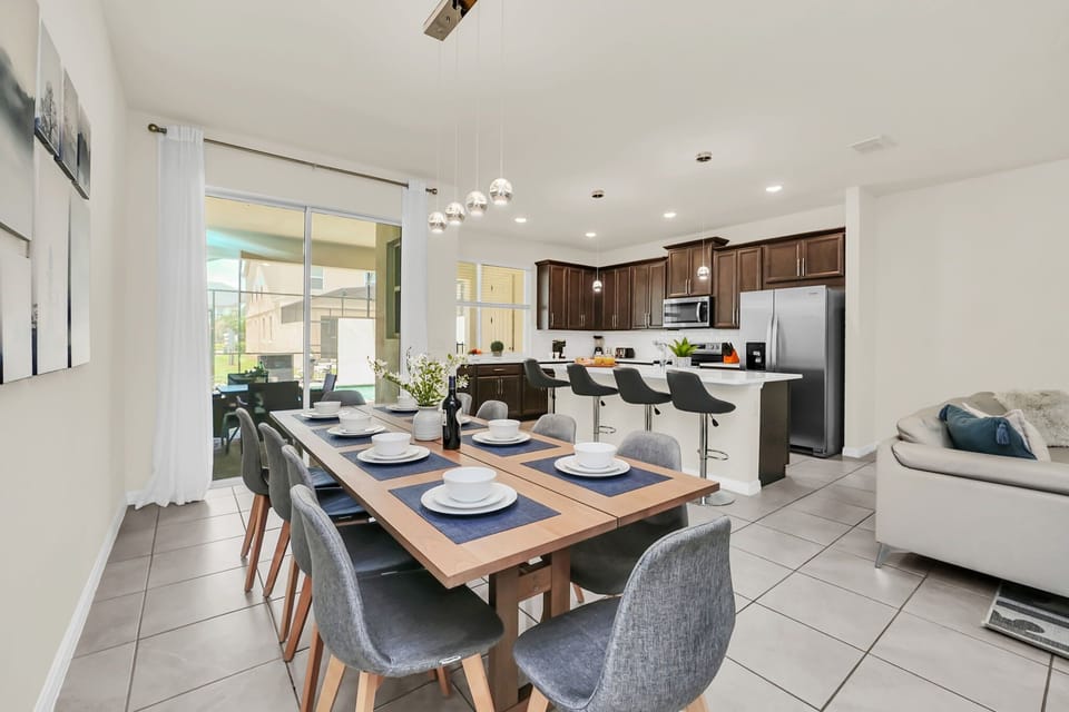 Modern kitchen and dining area with seating for eight and a view of the outdoor patio.