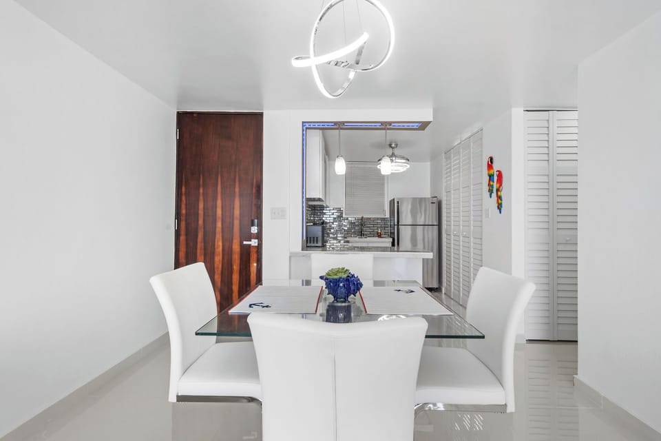 The modern dining table with 4 chairs is adjacent to the kithcen.