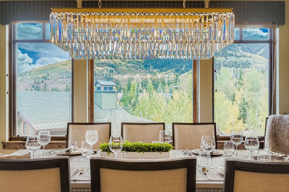Host unforgettable dinners in this elegant dining room featuring seating for eight and a striking crystal chandelier. Large windows frame scenic mountain views, creating a beautiful backdrop for every meal.