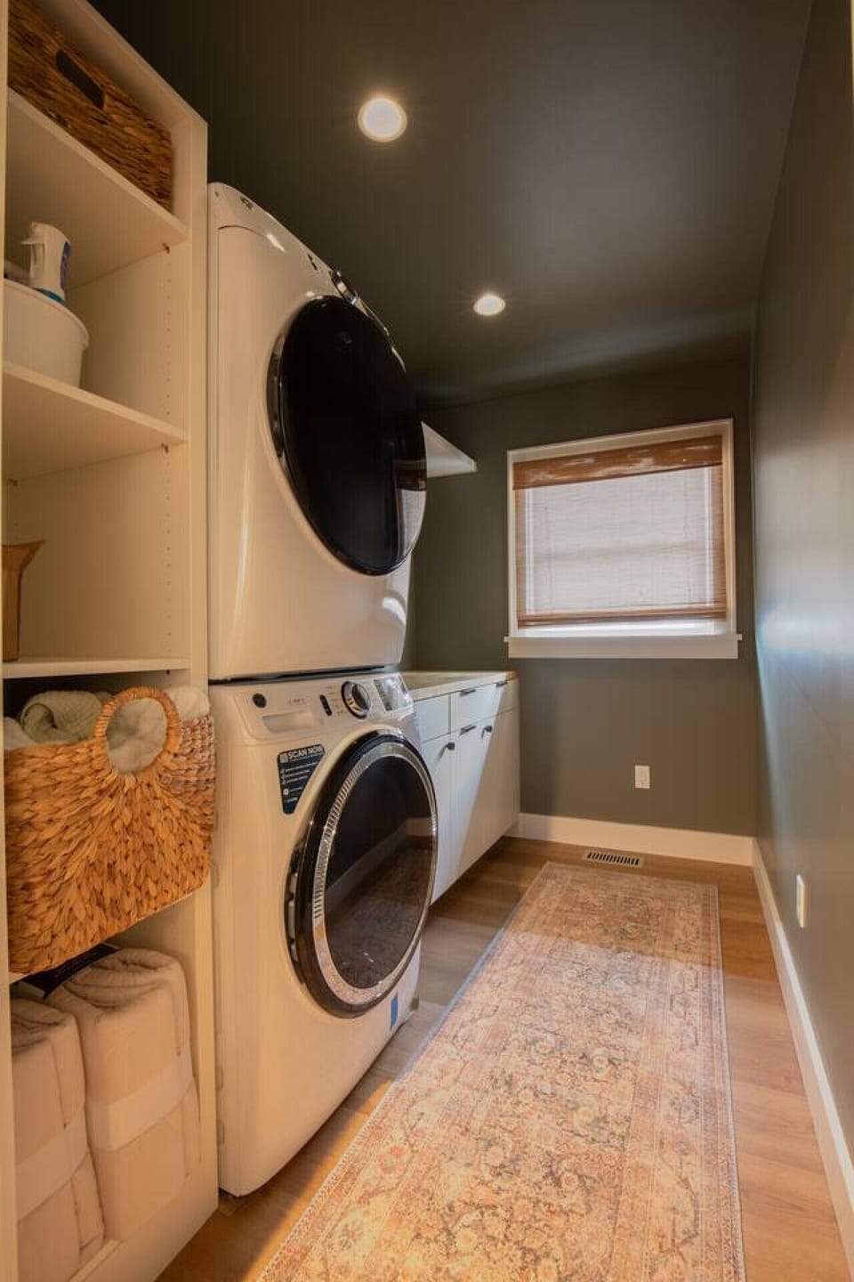 The laundry room has a large washer, dryer, and folding space