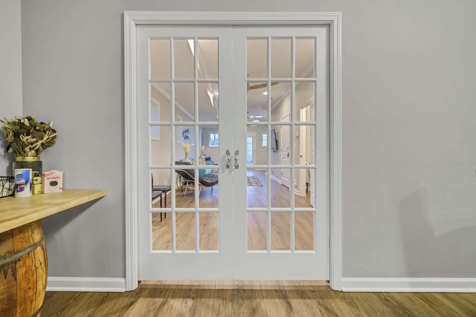 Living Room: Beautiful French doors open up to a warm and inviting living space, offering the perfect mix of style and comfort.