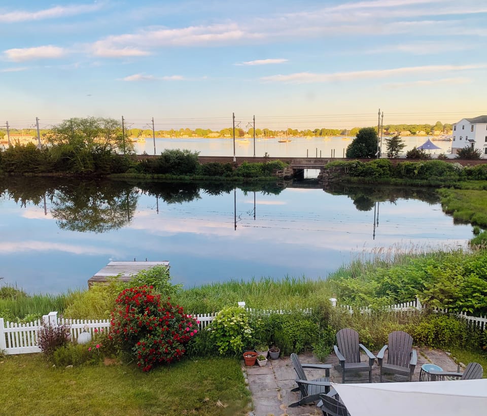 View of back of the house, fully fenced back yard, steps leading down to dock
