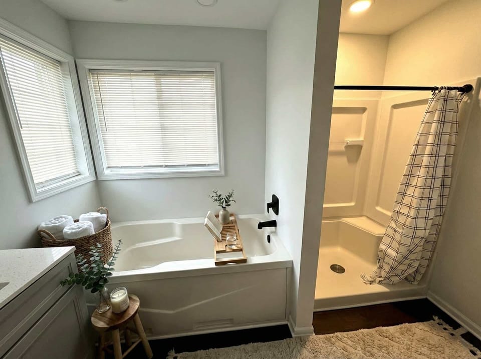 Bathroom with soaking tub, separate shower, vanity, and natural light.