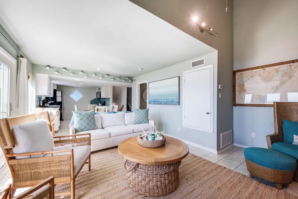 Sink into plush coastal comfort in your bright living space, where woven textures and ocean-inspired blues create the perfect retreat for relaxation.