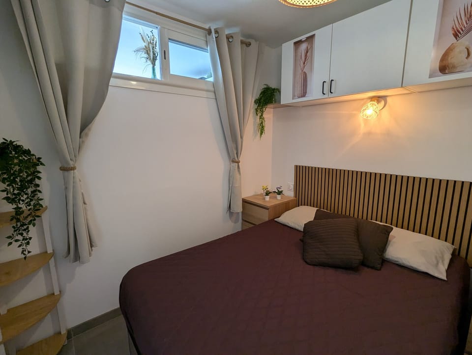 Room with a double bed and storage space, enjoying a pleasant natural light thanks to its window