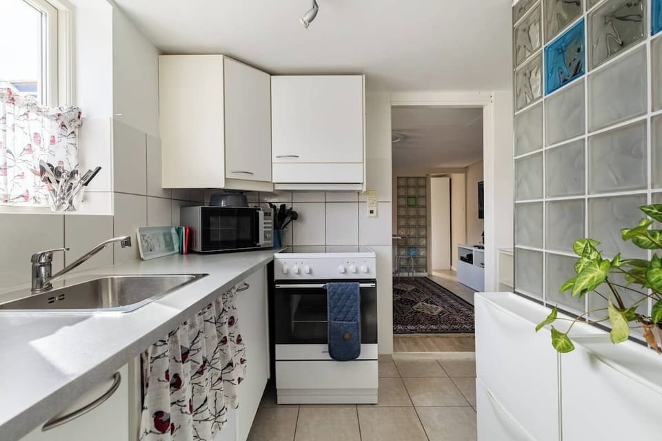 Oven and cooker, fully equipped kitchen with cookware with plates and glasses.
