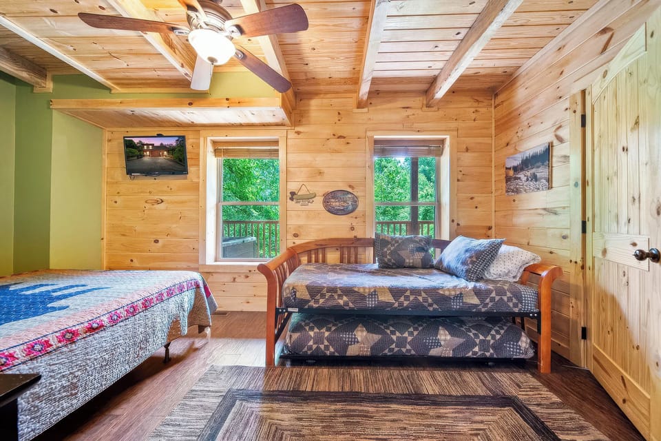 Extra sleeping space with a cozy trundle and deck access nearby.