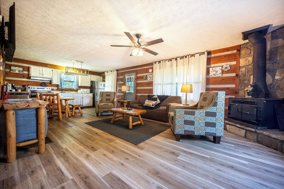 Living room area with a rustic fireplace and comfortable seating to unwind.