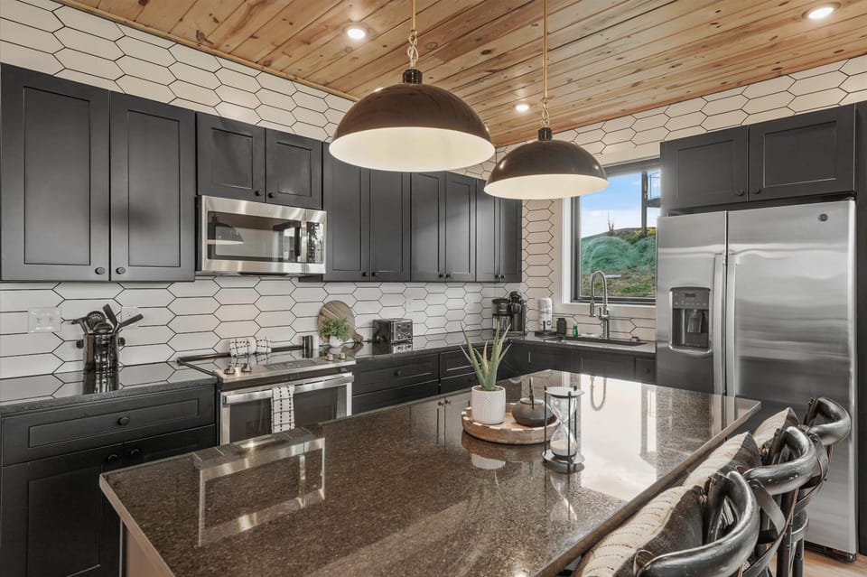 Stylish space with sleek black cabinets and modern appliances for culinary adventures!