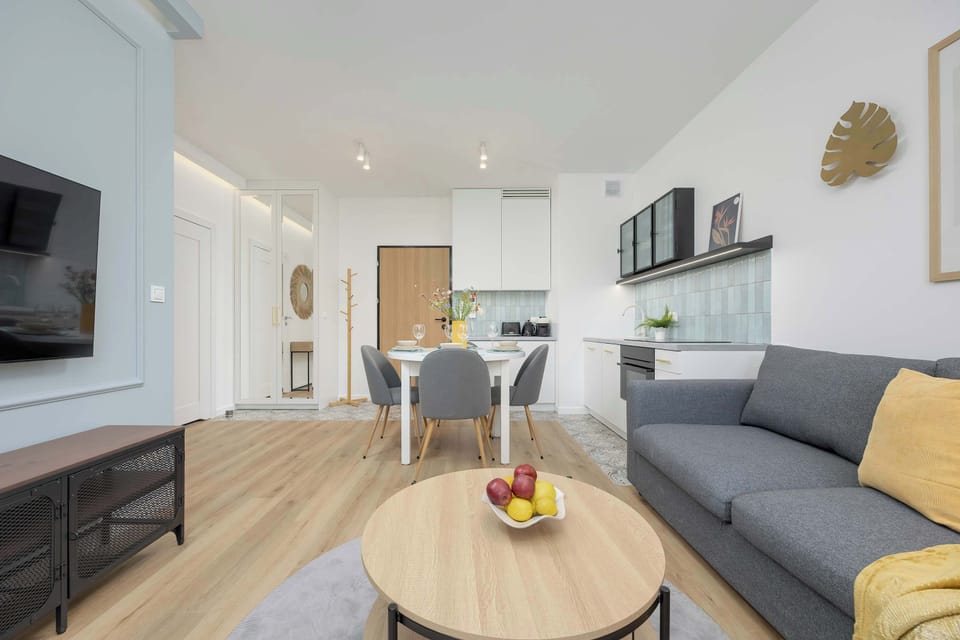 A spacious lounge area with an open hallway, TV console, and soft ambient lighting.

