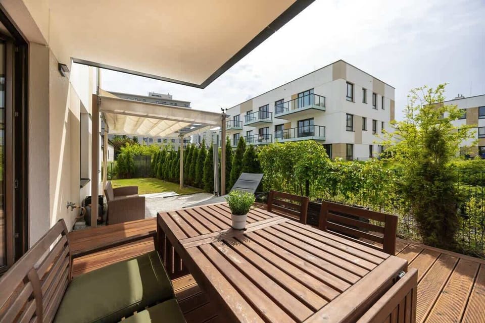  A terrace with a comfy seating set and lush greenery provides privacy and outdoor comfort.