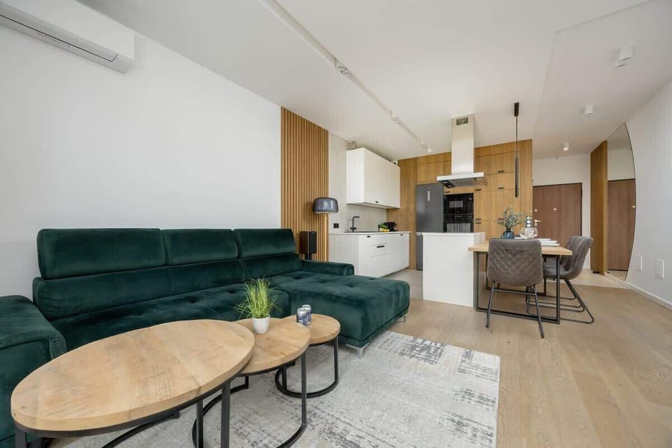 A stylish living room with a green sofa, wooden coffee table, and bright flooring combines modern character with homely warmth.