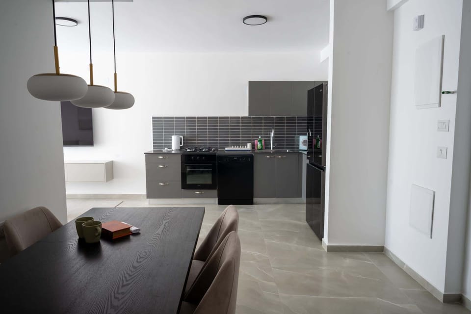 Dining space beside kitchen encourages shared meals before evening walks toward the waterfront promenade nearby.