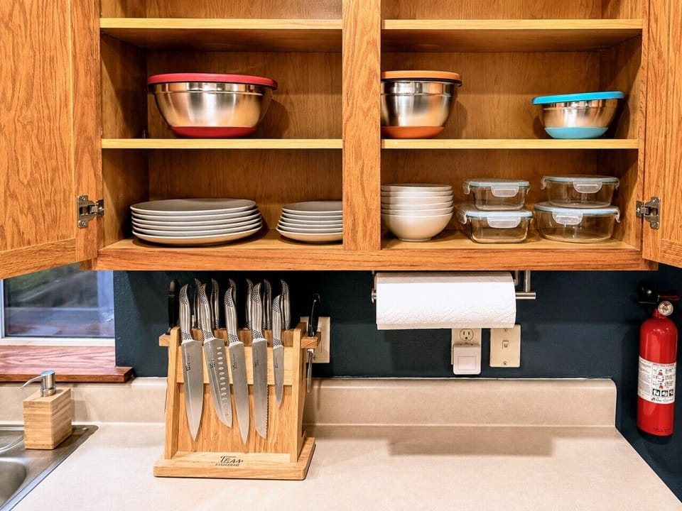 Stocked cabinets with dishes, bowls, cookware, and useful kitchen essentials.