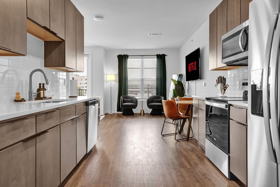 Modern kitchen with sleek stainless steel appliances and neatly arranged utensils, perfect for effortless cooking during your short-term rental stay.