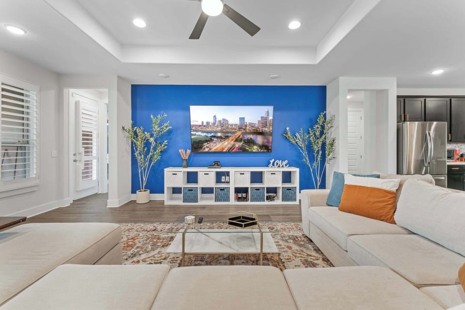Living room with 85" 4K TV, PS4 and various games, and oversized spacious seating