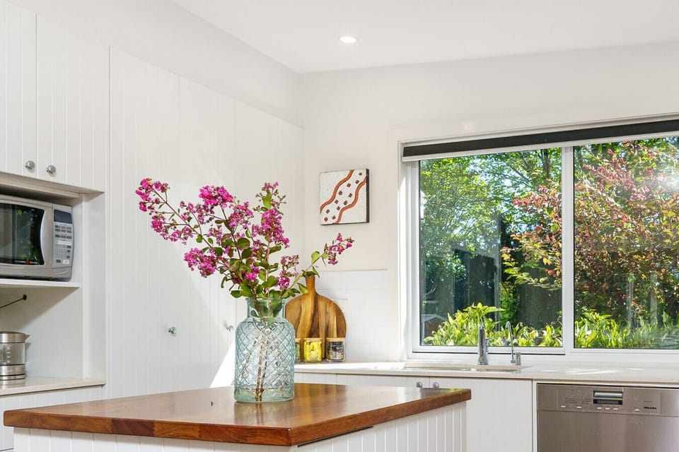 Beautiful, well-equipped kitchen with everything you need to cook and enjoy meals, including a Nespresso machine with pods provided. A bright window offers a serene view of lush greenery, bringing nature right to your doorstep.