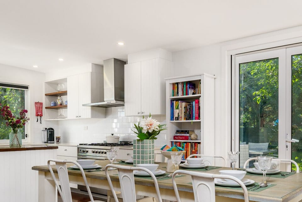 Spacious 6-seater dining table surrounded by large windows, offering picturesque views and abundant natural light for a delightful dining experience.