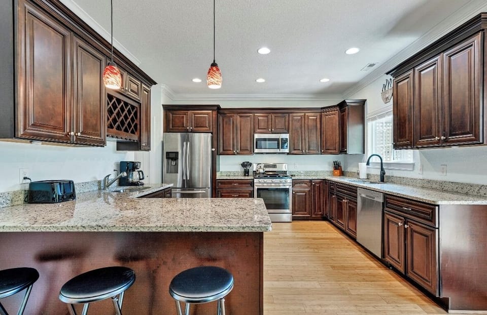 Fully stocked kitchen with granite counters and bar seating.
