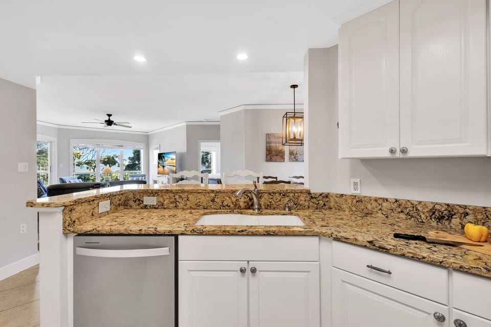 A fully-equipped kitchen with granite countertops has everything necessary to cook and serve basic meals