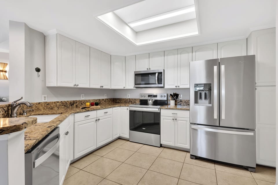 A fully-equipped kitchen with granite countertops has everything necessary to cook and serve basic meals