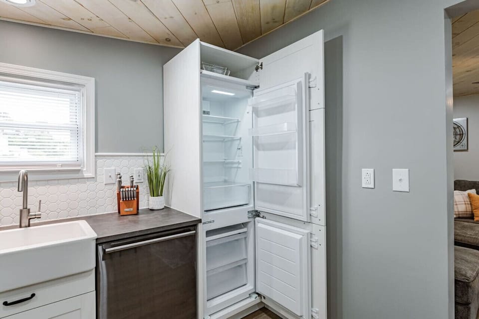 Cook and entertain with ease in the fully equipped kitchen, featuring a coffee station with Keurig and drip options, modern appliances, a farmhouse sink, and a charming dining area with bench seating.