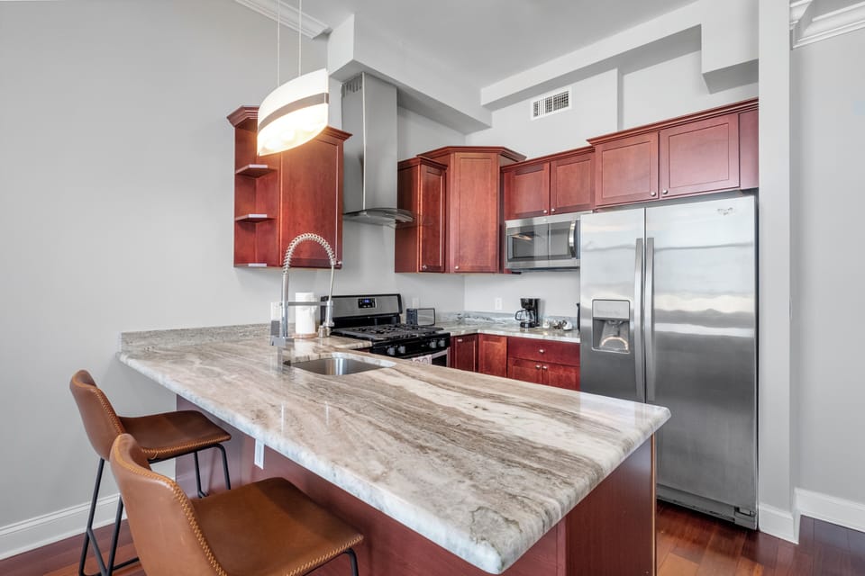 Fully-equipped kitchen with cherry wood cabinets, stainless appliances, and granite counters ideal for preparing home-cooked meals.