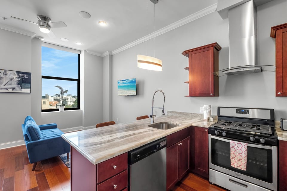 Open-concept kitchen and living space with cherry cabinetry and hardwood floors maximizing space.