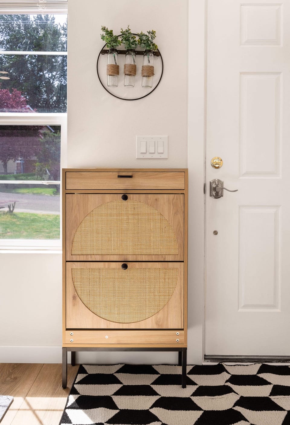 "Step into a welcoming entryway with stylish decor and a touch of greenery to greet you as you enter.