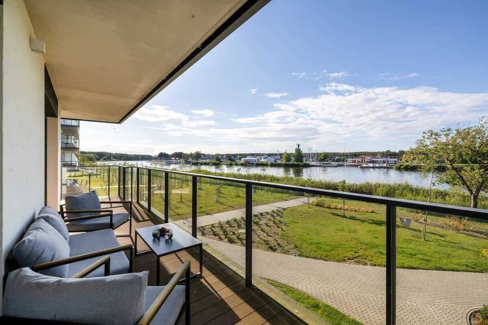 The view from the balcony of a green landscape with a river in the background creates a peaceful and picturesque atmosphere.