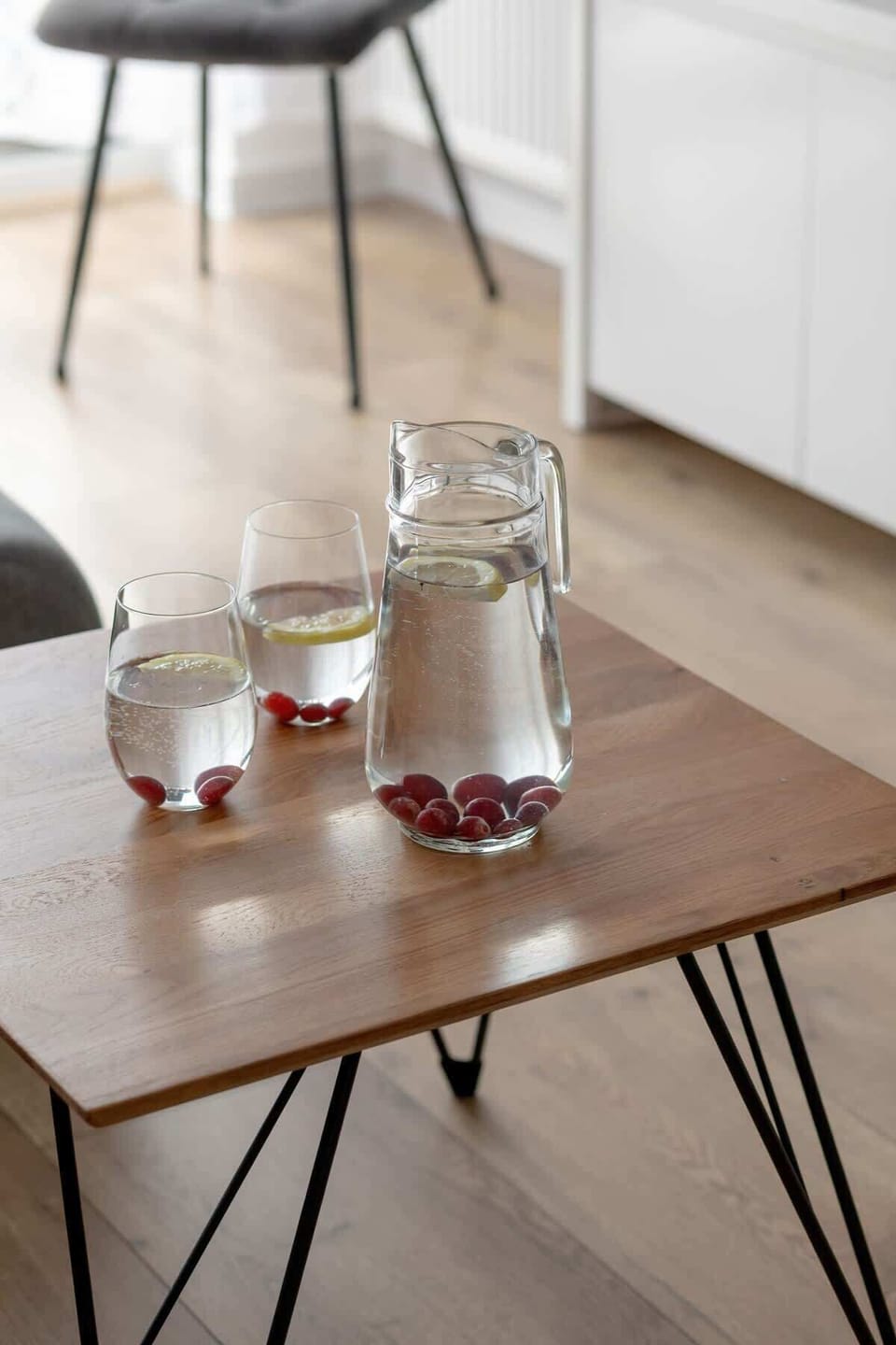 A wooden table with two glasses of water and cherries adds a natural, homely touch to the interior.