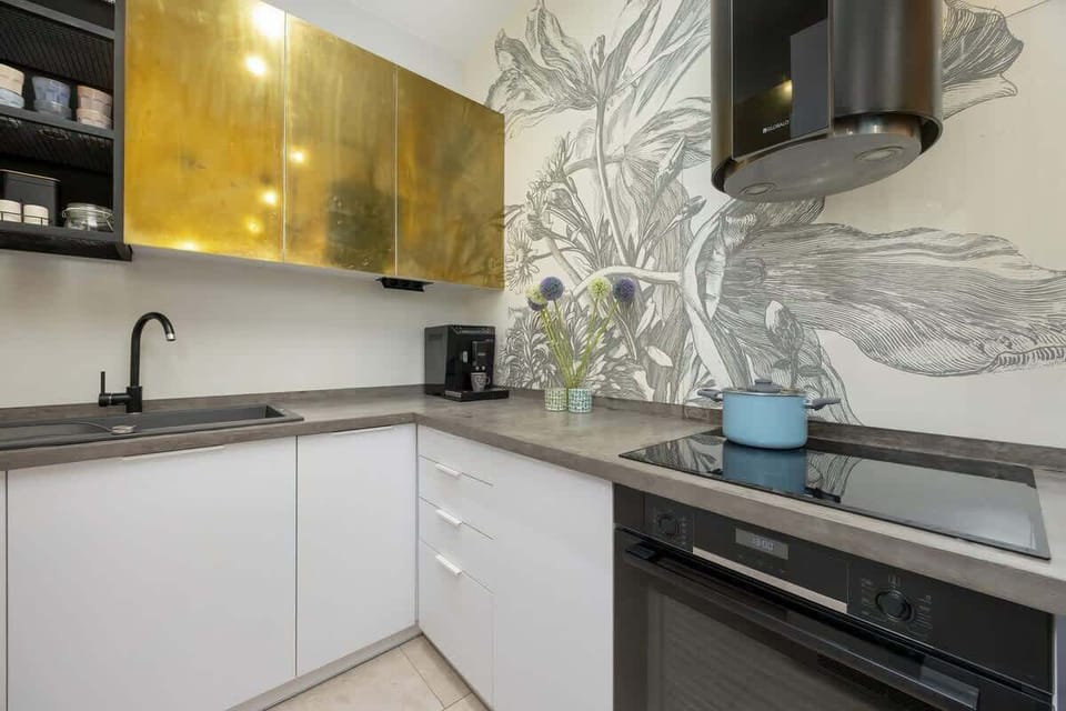 An elegant kitchenette with glossy cabinets and a practical layout is perfect for short stays.
