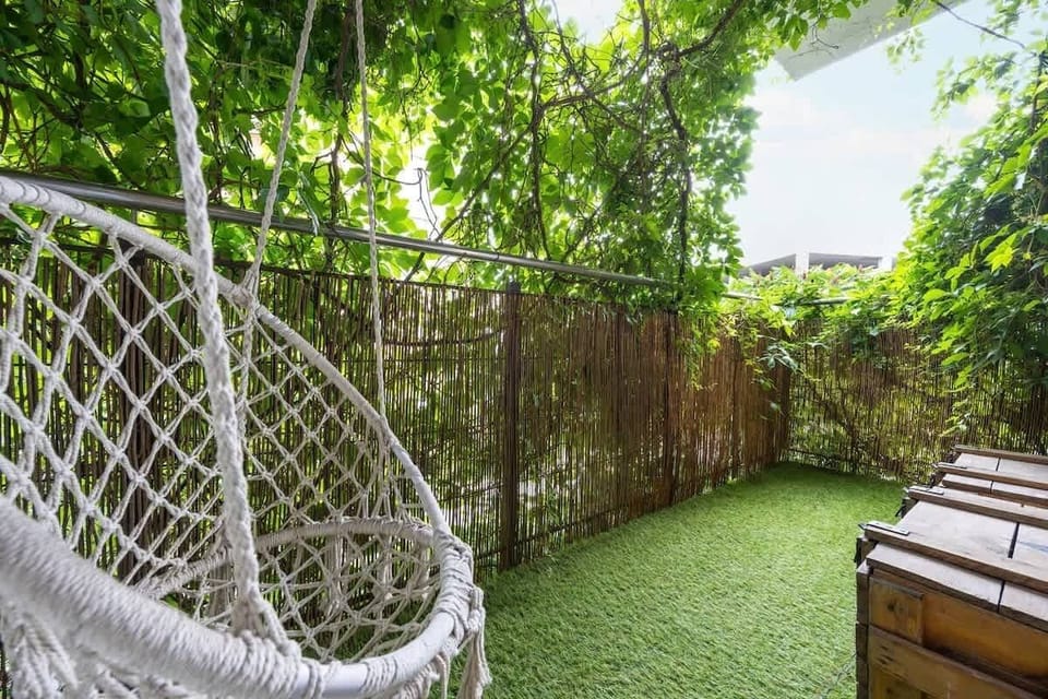  The green terrace with a swing and grass flooring is a perfect spot for outdoor relaxation.