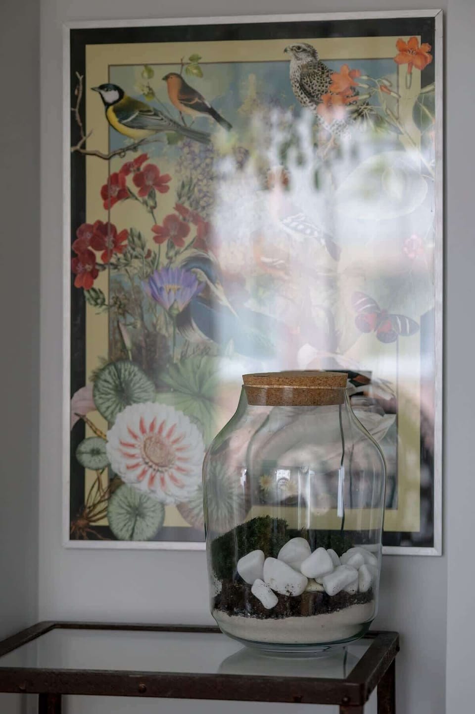 A decorative lamp in front of a floral curtain adds an artistic and cozy touch to the interior.