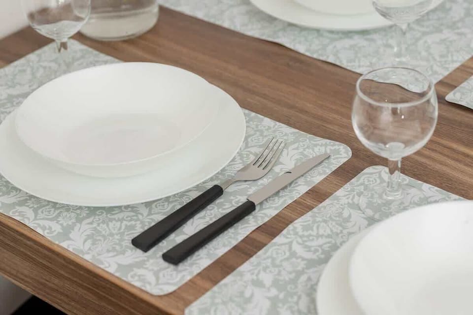 A well-set dining table with white dinnerware and a decorative runner invites shared meals.